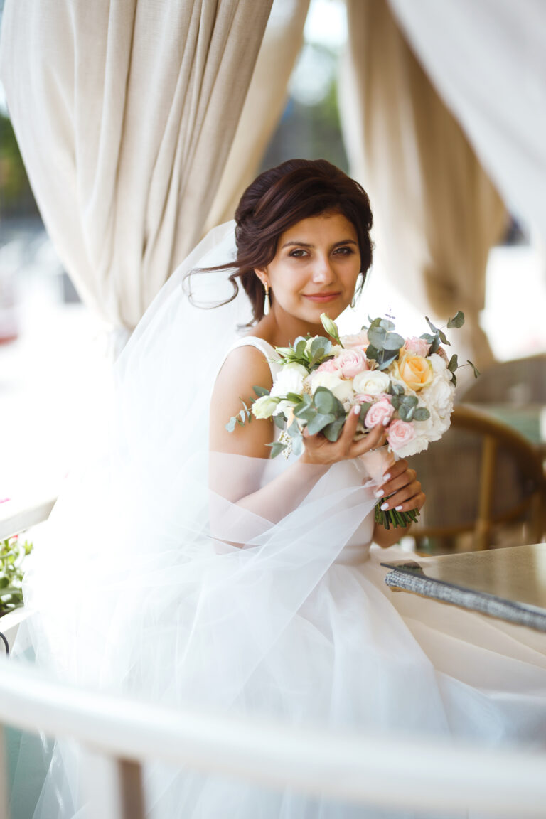 Beautiful bride with wedding flowers bouquet, attractive woman in wedding dress.