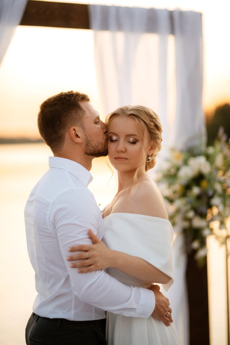 Close up groom kissing bride on cheek