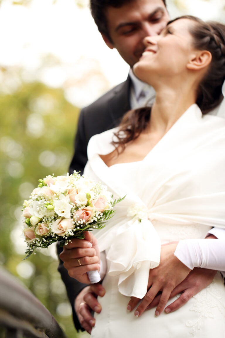Bride and Groom smiling at each other. Bride holding bouquet