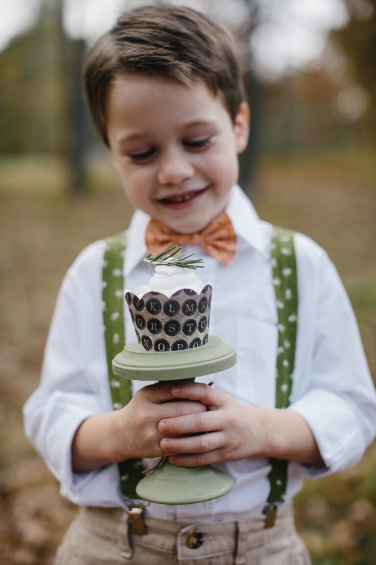 Ring Bearer boy smiling holding cupcake