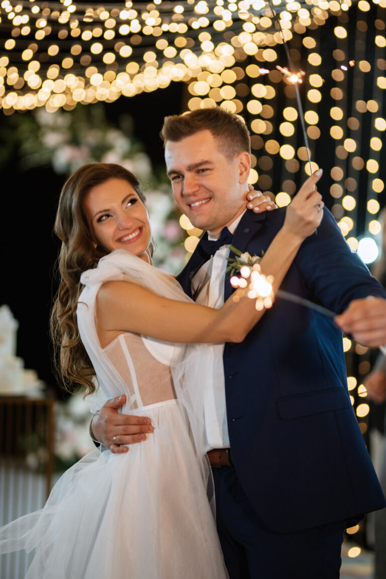 Bride and Groom holding sparkler with lighted background