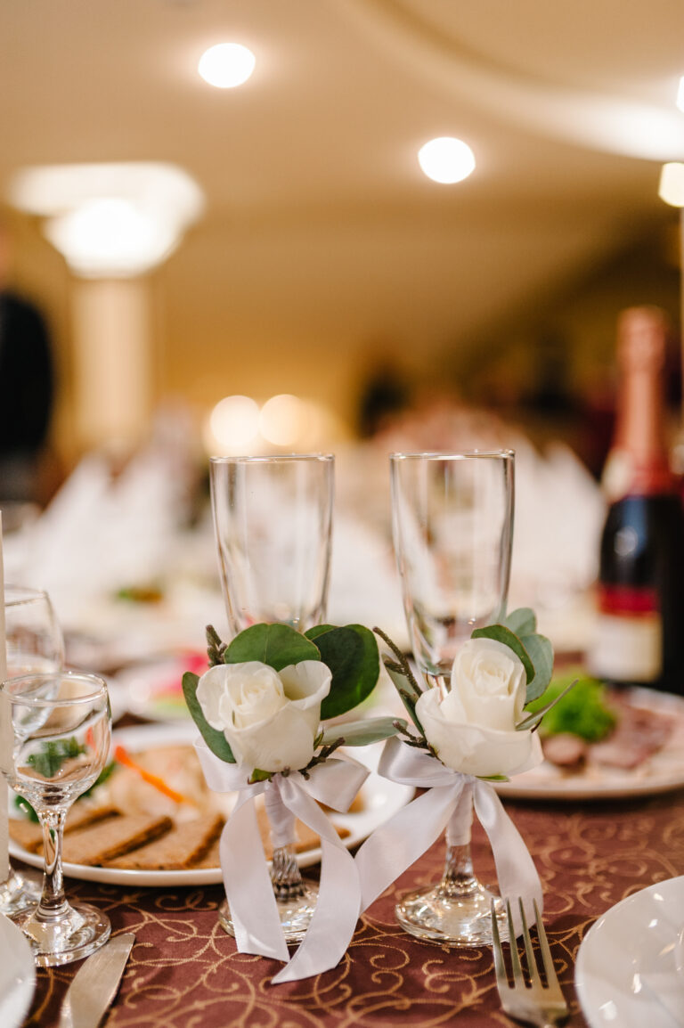 Two Wedding glasses are decorated flowers with ribbons. Close up