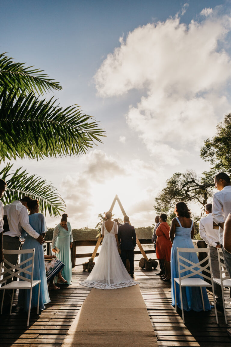 outdoor wedding altar with the bride and groom with guests under the sky